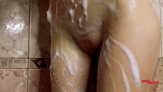 Худая красотка Николь соблазнительно играет с мыльной пеной под струями воды